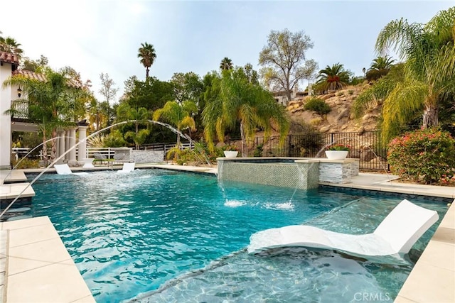 view of swimming pool featuring pool water feature and an in ground hot tub