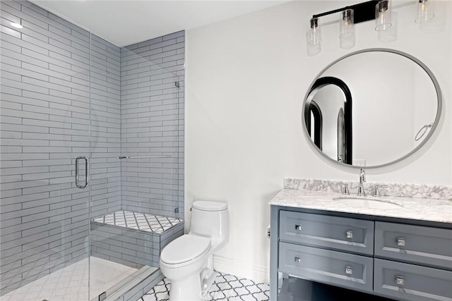 bathroom featuring tile patterned floors, vanity, toilet, and an enclosed shower