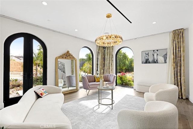 interior space with french doors, light wood-type flooring, and a notable chandelier