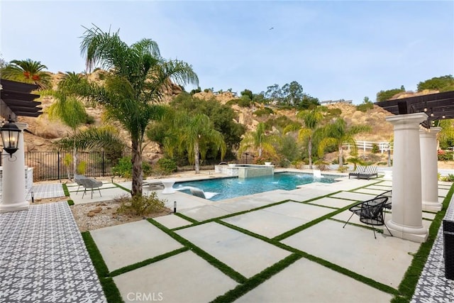 view of pool featuring an in ground hot tub, pool water feature, and a patio area