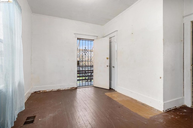 unfurnished room featuring dark hardwood / wood-style floors and ornamental molding