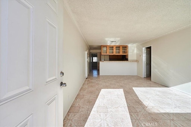 unfurnished living room featuring a textured ceiling, light tile patterned floors, and crown molding