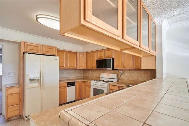 kitchen with tasteful backsplash, tile countertops, white appliances, and ornamental molding