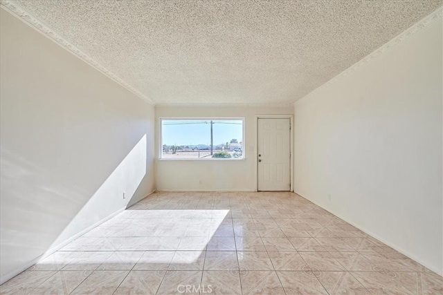 spare room with light tile patterned floors and a textured ceiling