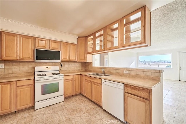 kitchen featuring white appliances, tasteful backsplash, sink, kitchen peninsula, and light tile patterned floors