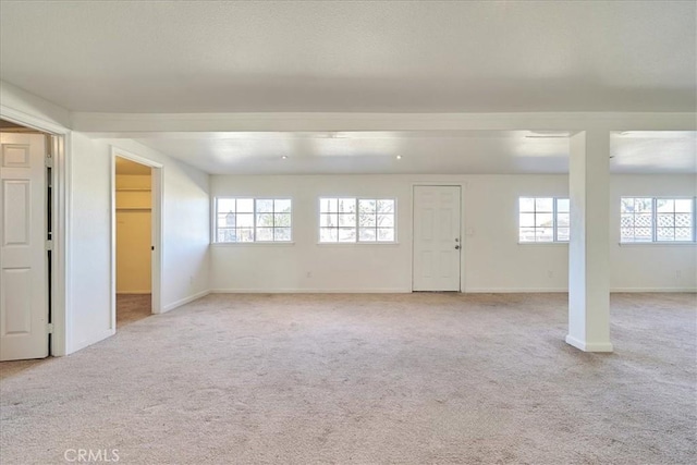 basement featuring light colored carpet and a wealth of natural light