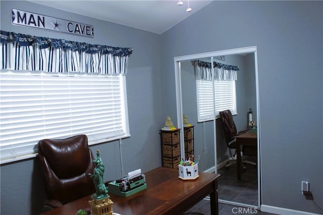 home office with vaulted ceiling and tile patterned floors