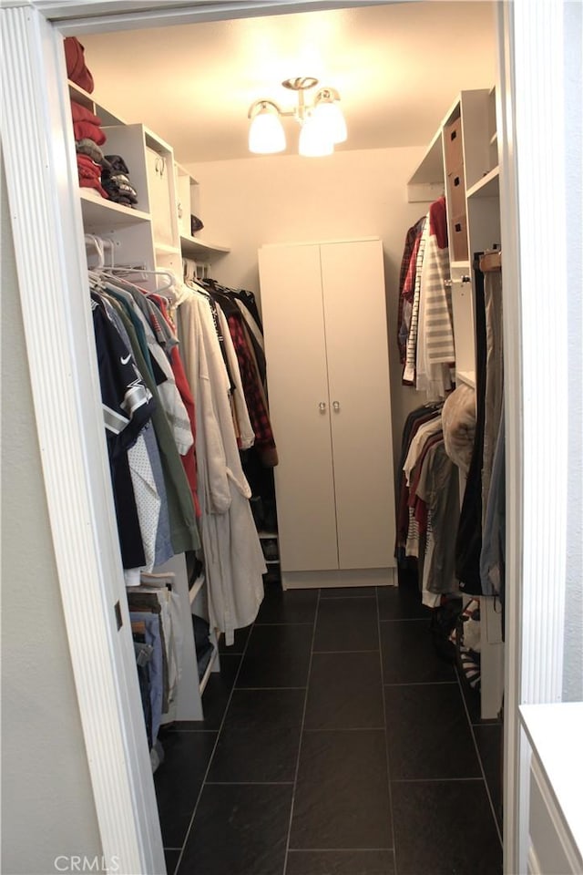 spacious closet with dark tile patterned floors