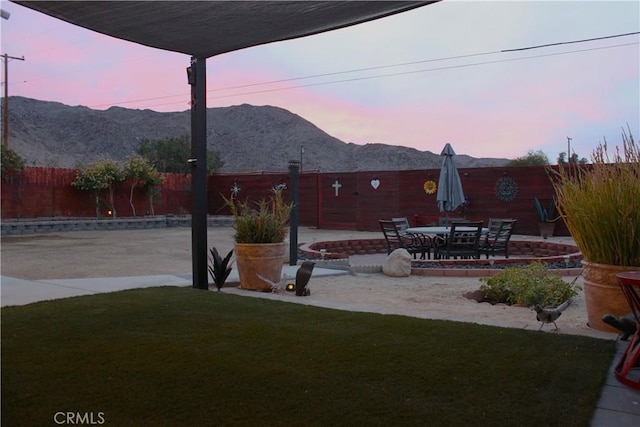 yard at dusk with a mountain view and a patio