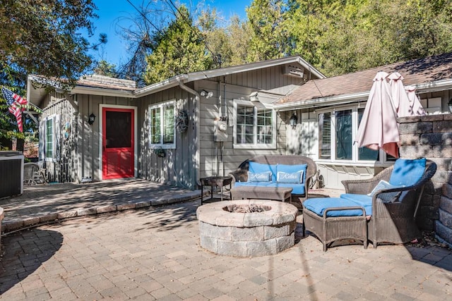 rear view of house with a patio area and an outdoor living space with a fire pit