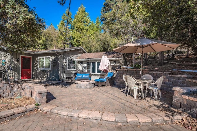 view of patio with an outdoor living space with a fire pit