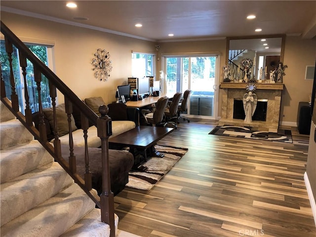 dining area featuring crown molding, hardwood / wood-style floors, and a high end fireplace