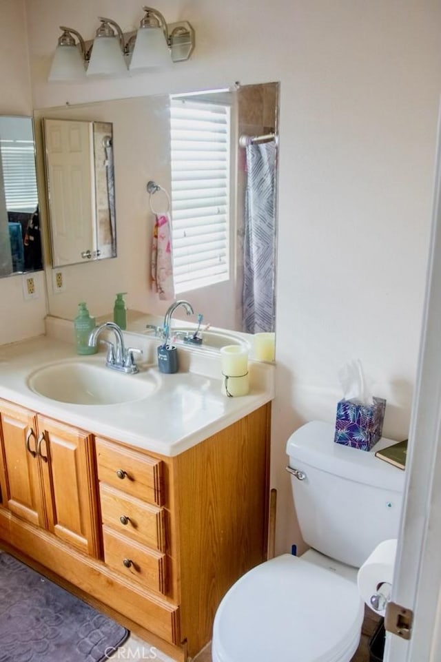 full bathroom featuring curtained shower, vanity, and toilet