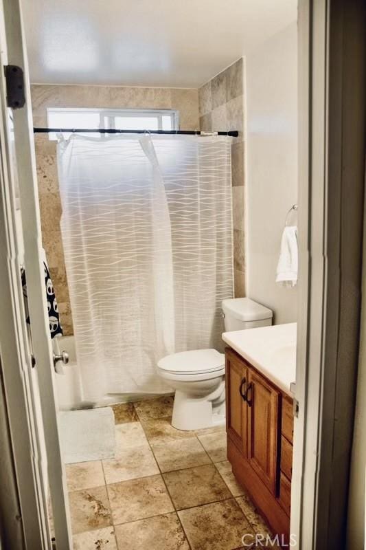 full bath featuring shower / tub combo, vanity, and toilet