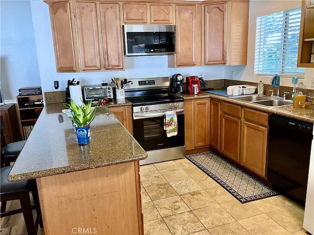 kitchen with a toaster, appliances with stainless steel finishes, dark stone countertops, a kitchen bar, and a sink