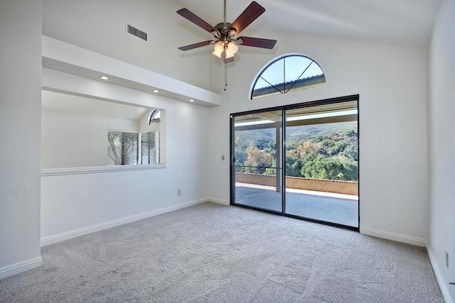 carpeted spare room featuring high vaulted ceiling and ceiling fan