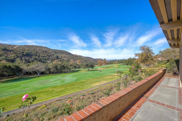 surrounding community with a yard and a mountain view