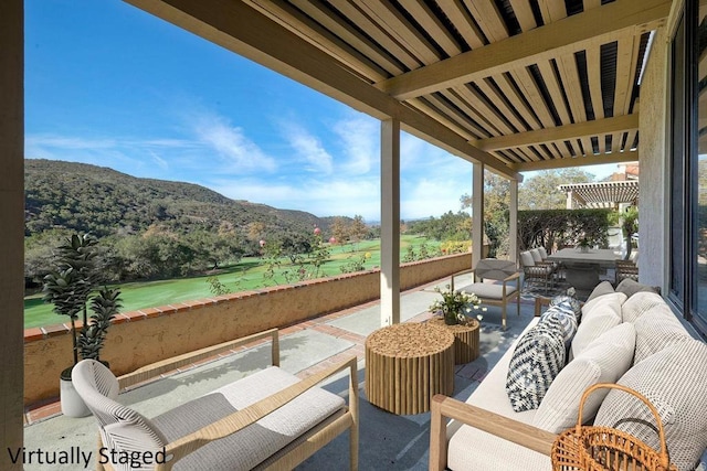 balcony with an outdoor living space, a mountain view, and a patio