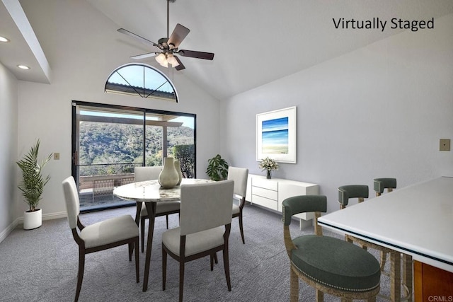 carpeted dining space featuring high vaulted ceiling and ceiling fan