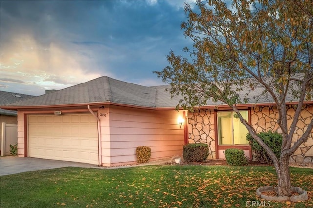 ranch-style house with a garage and a lawn