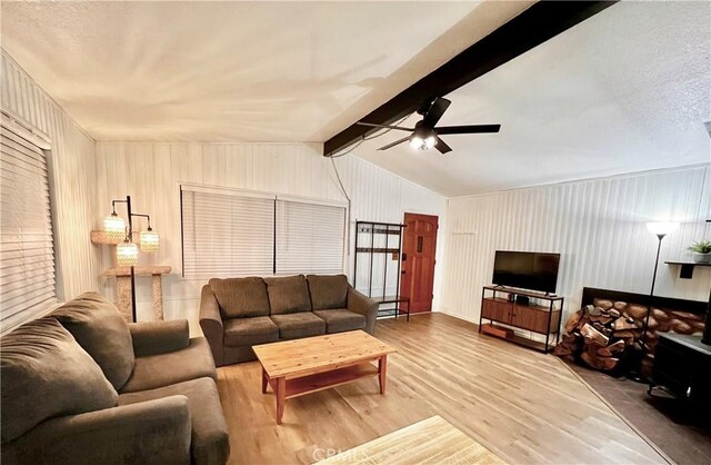 living room featuring ceiling fan, lofted ceiling with beams, and wood-type flooring