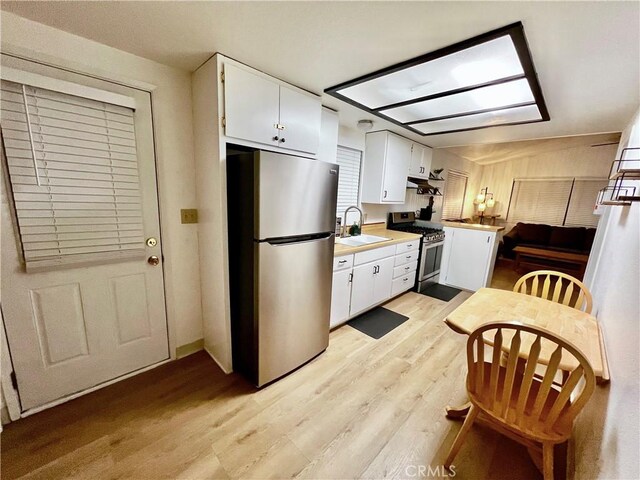 206 E Barker Blvd, Big Bear City, CA 92314 - kitchen featuring appliances with stainless steel finishes, light wood-type flooring, a sink, light countertops, and white cabinets