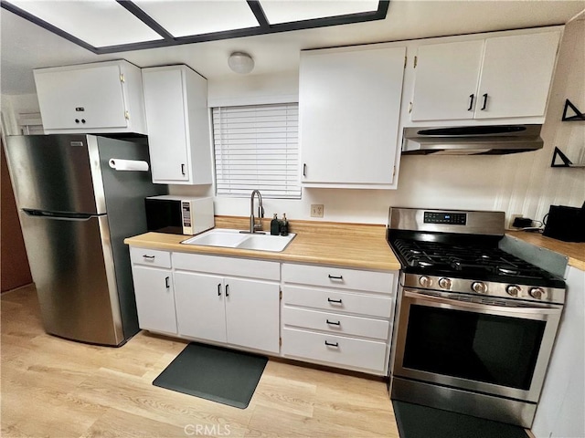 kitchen with sink, white cabinets, stainless steel appliances, and light wood-type flooring