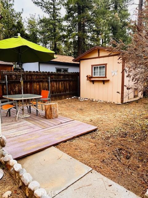 206 E Barker Blvd, Big Bear City, CA 92314 - exterior space with a deck, an outbuilding, fence, a shed, and outdoor dining space