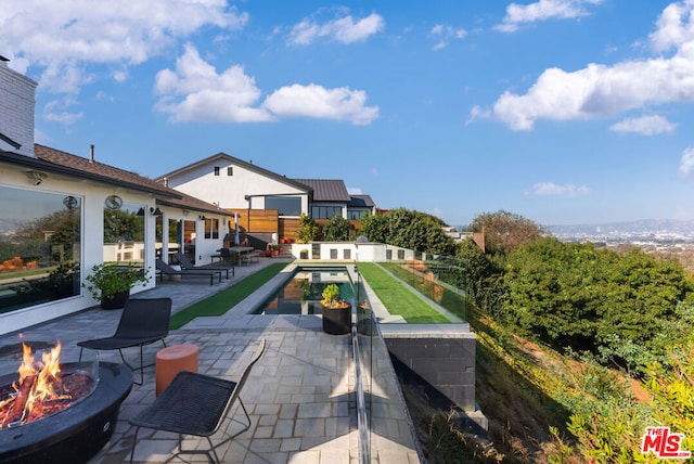 view of swimming pool with a patio area and an outdoor fire pit