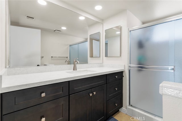 bathroom with vanity, tile patterned floors, and a shower with door