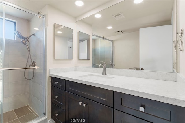 bathroom featuring vanity and an enclosed shower