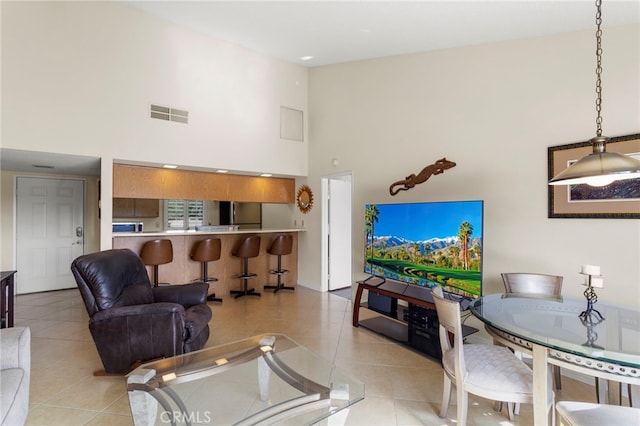 living room featuring light tile patterned floors and a high ceiling