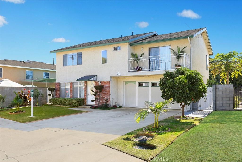 view of front of home with a balcony and a front yard