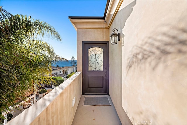 view of exterior entry with a balcony