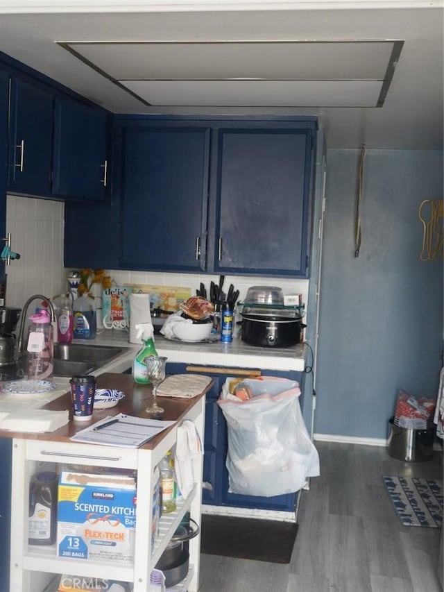 kitchen featuring blue cabinetry, dark hardwood / wood-style flooring, and sink