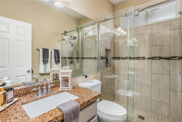 full bathroom with a shower stall, toilet, and vanity