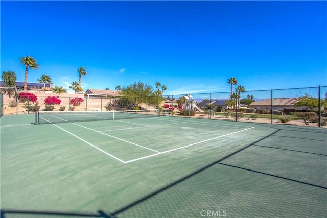 view of tennis court featuring fence