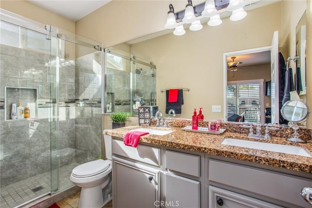 bathroom with a stall shower, a sink, toilet, and double vanity