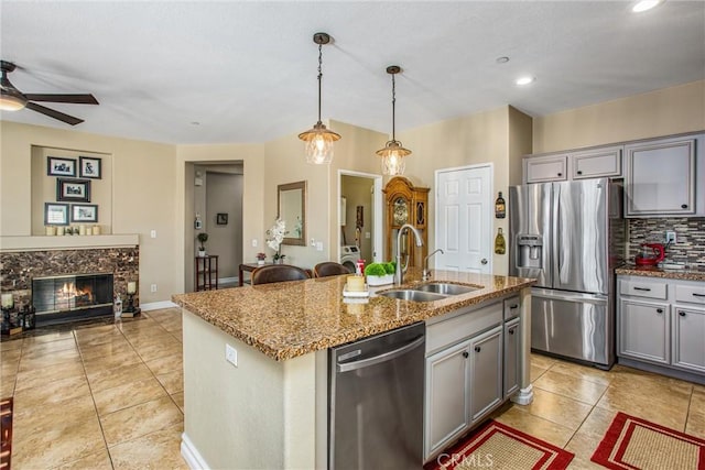 kitchen with open floor plan, stainless steel appliances, gray cabinets, and a sink