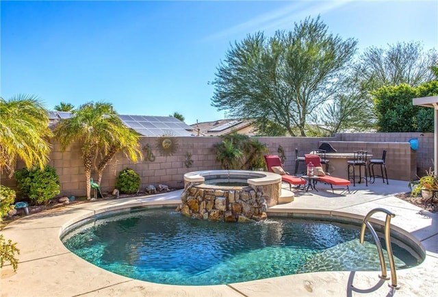 view of pool with pool water feature, a patio, and an outdoor bar