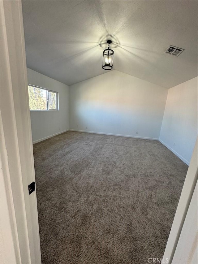 empty room with lofted ceiling and carpet floors