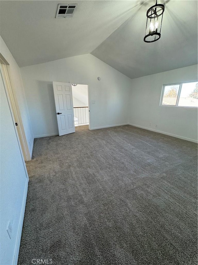 empty room featuring dark carpet and lofted ceiling