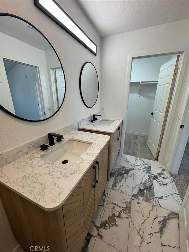 bathroom featuring hardwood / wood-style flooring, vanity, and a textured ceiling