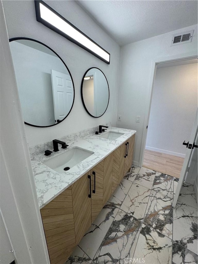 bathroom with vanity and a textured ceiling