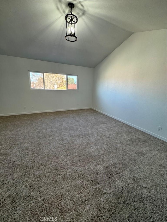 carpeted empty room with lofted ceiling