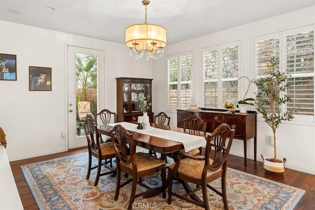 dining area with dark hardwood / wood-style flooring and a chandelier