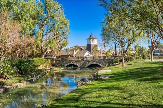 surrounding community with a yard and a water view