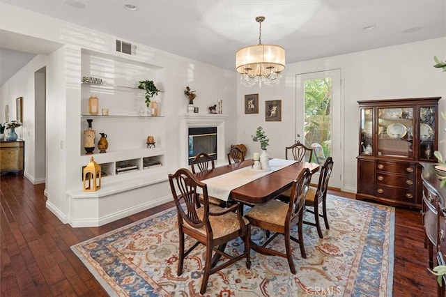 dining area featuring dark hardwood / wood-style flooring and a notable chandelier