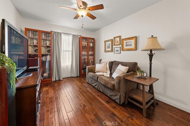 living area featuring ceiling fan and dark hardwood / wood-style flooring