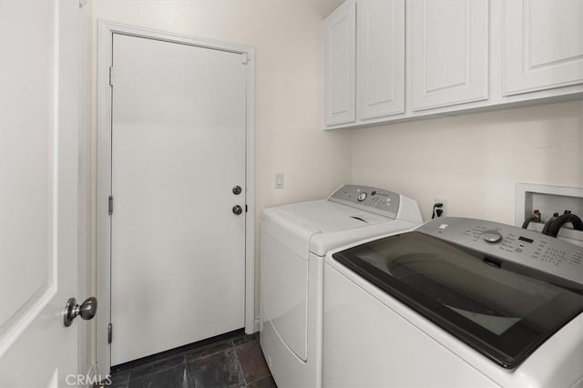 clothes washing area with washer and dryer and cabinets